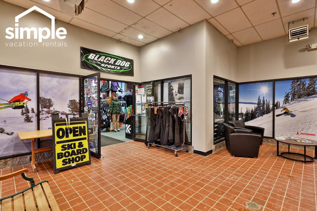 This image captures the entrance to the on-site ski and board shop, complete with vibrant sports gear displays and informative signage. Active guests interact with staff, highlighting the convenience and adventure-oriented amenities available to families and groups.