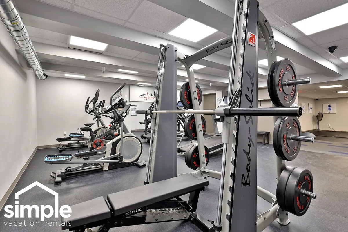 A dynamic fitness center scene, featuring weightlifting equipment, exercise bikes, and free weights in an invigorating and focused environment. The space is designed for both personal and group workouts, capturing the energy and inclusiveness of a 24/7 fitness facility.