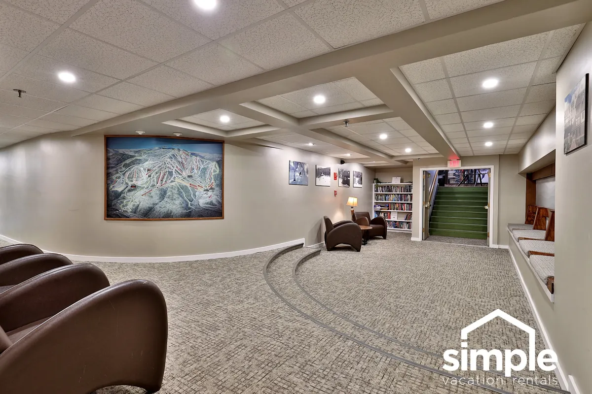 A communal space with plush seating areas, a bookshelf filled with books, and prominent local artwork. The arrangement suggests a sociable environment where guests can mingle, read, or simply enjoy the ambiance.