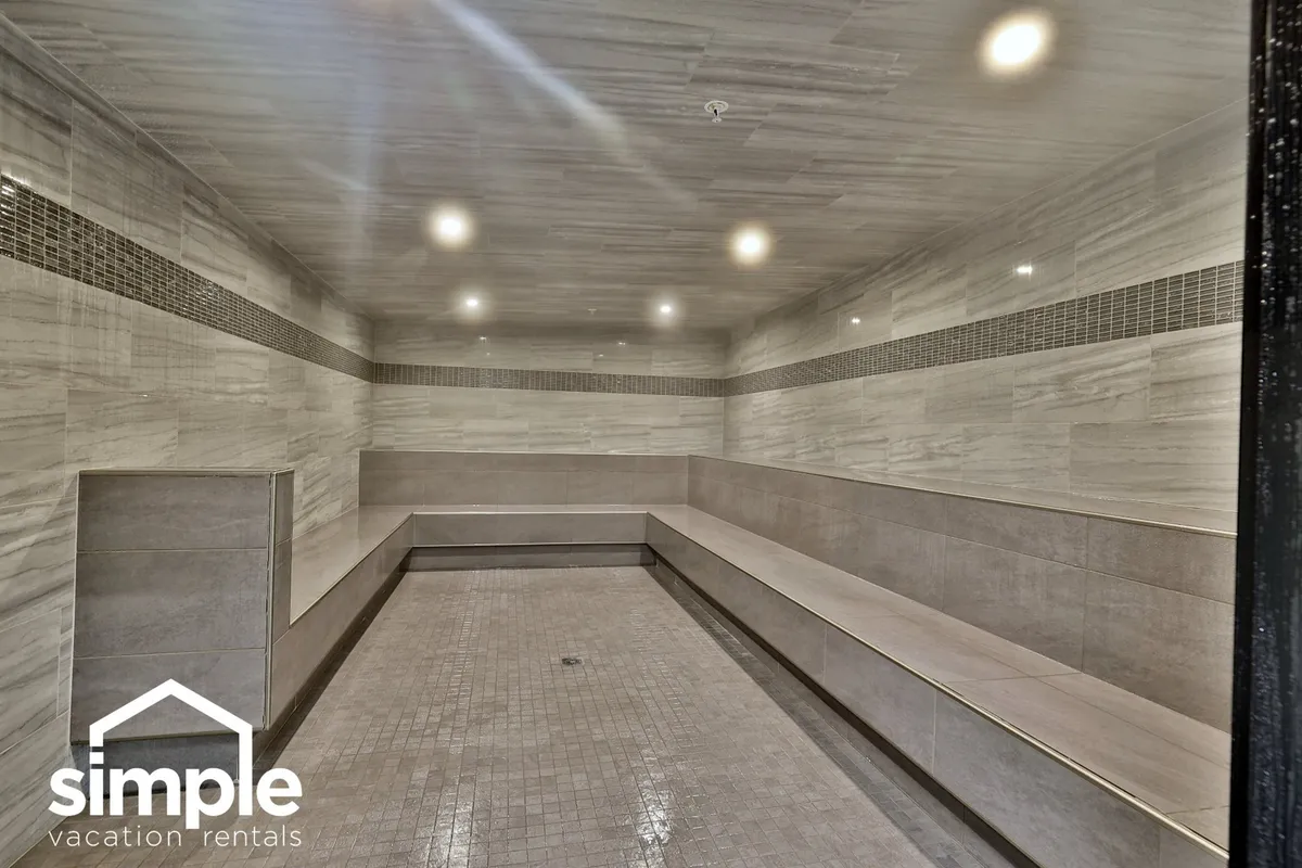 A serene wellness space with benches, textured walls, and ambient lighting, designed for relaxation and quiet reflection after an active day outdoors. The minimalist decor and spa-like mood evoke a sense of post-adventure calm.